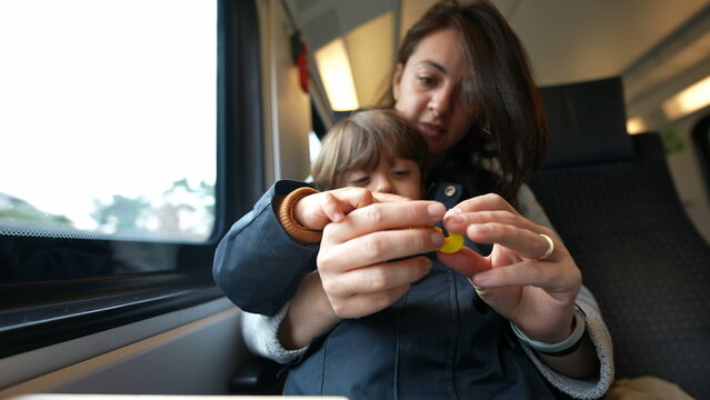Focused mother guiding her son in counting during a train journey, embodying the essence of homeschooling and childhood learning on-the-go