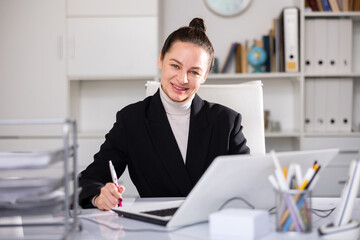 Portrait of business woman working at her workplace with laptop