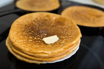 Stack of appetizing flour pancakes in the kitchen during cooking