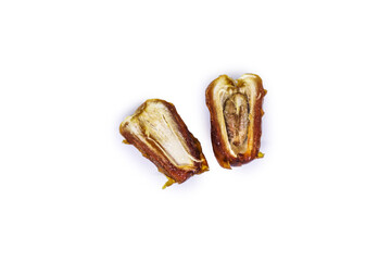 Close-up view of delicious golden Sukkari dates sliced in half showing the date flesh and seeds inside isolated on a white background. Ramadan Arabic food concept top view.