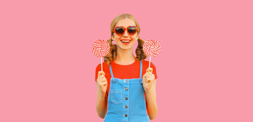 Summer portrait of happy smiling girl with colorful lollipop wearing red heart shaped sunglasses...