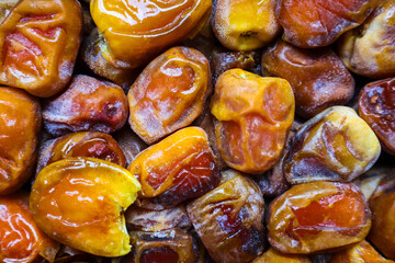 A pile of fresh and tasty Golden Sukkari Dates fruit. Sweet and soft dates. Top view. Arabic healthy food concept. Sukkari dates texture backgrounds. Vertical Food Photograph.