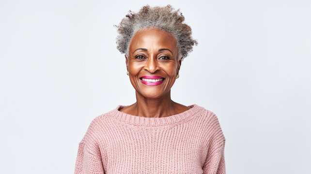 Happy Black Senior Woman Wearing Cosy Sweater In A Studio Shoot Standing Against Grey Background.

