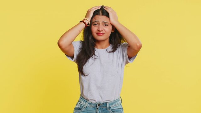 Sad young Indian woman feeling hopelessness loneliness, nervous breakdown loses becoming surprised by lottery results bad fortune loss unlucky news. Attractive Hindu girl isolated on yellow background