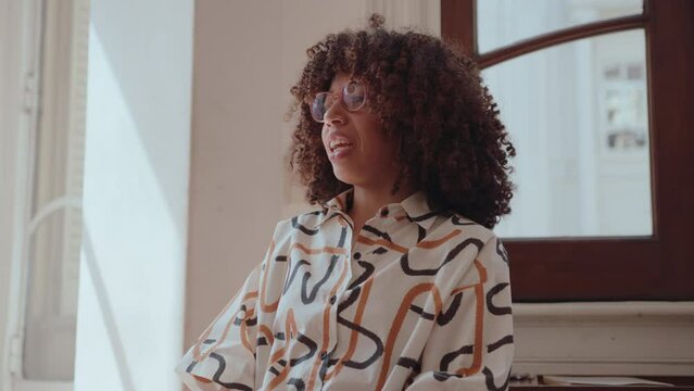 Young black woman with curly hair talking openly about her personal experience and mental health problems in group therapy