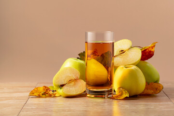 Apple juice and ripe apples with dried-up leaves.