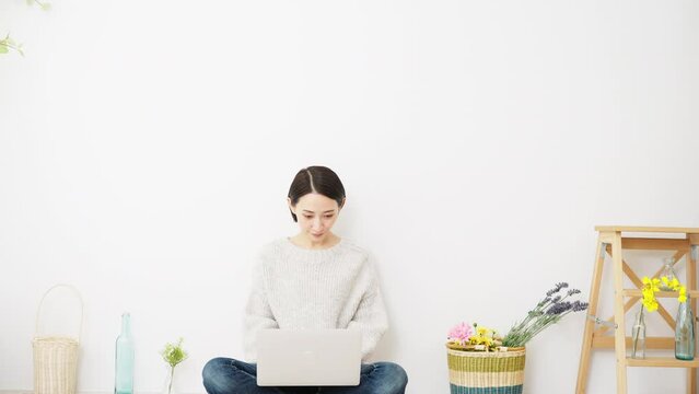 ノートパソコンを操作する若い女性　ライフスタイルイメージ