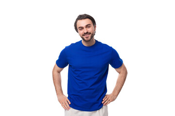 portrait of a young stylish caucasian brunette man with a beard in a blue t-shirt