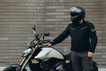 Man biker standing by his motorbike