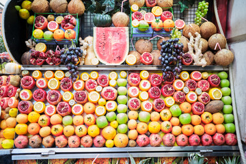 A collection of pomegranates, apples, oranges, kiwis, grapes, watermelon, coconuts, lemons, pumpkins