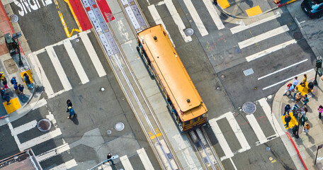 Trolley aerial above busy San Francisco street with tourists and pedestrians at crosswalks, CA