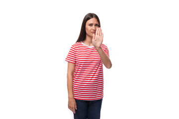 35 year old european lady in a red striped t-shirt shows a gesture of refusal and disagreement