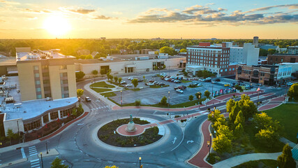 Native American statue Passing of the Buffalo beside hotel at sunset in Muncie, IN aerial