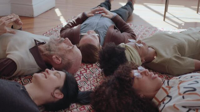 People lying down on the floor, looking upwards and having discussion, sharing problems and personal experience with each other in group therapy