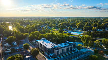 Apartment building aerial Muncie, IN with Tuhey Pool on other side of White River in late afternoon