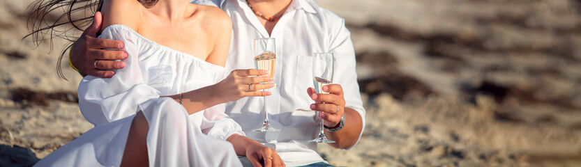 Couple in love celebrate wedding on beach with champagne
