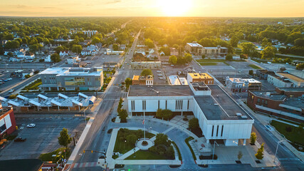 Courthouse, Muncie, IN at sunset with golden sun setting in aerial of downtown and neighborhood
