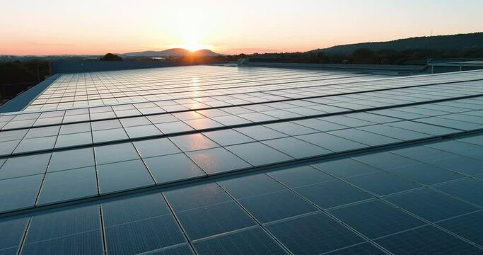 Aerial.  Sunlight catching solar power panels on top of a building in South Africa. Green renewable energy. Climate change, Global warming