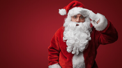 Thoughtful Santa Claus peering over glasses, searching for the naughty or nice