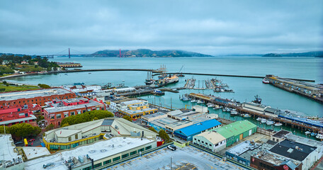 Aquatic Park Cove with Hyde St Pier and docked boats near wharf and distant Golden Gate Bridge aerial, San Francisco, CA - obrazy, fototapety, plakaty
