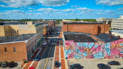 Wall graffiti mural art on gorgeous sunny summer day with blue skies in Muncie city aerial, IN