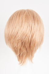 Fototapeta premium Natural looking blonde fair wig on white mannequin head. Short hair cut on the plastic wig holder isolated on white background, back view.