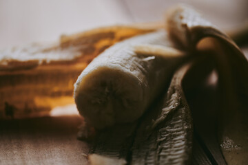 Close-up of peeled sliced banana on wooden table background