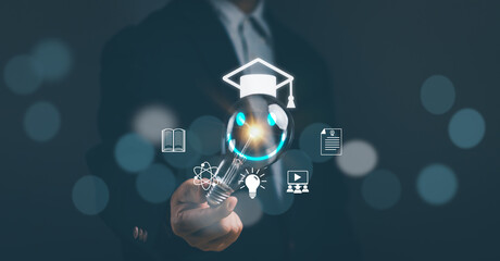 Concept of modern educational technology learning curriculum or online classroom learning.Man hand holds light bulb to learn an educational curriculum to develop skills with virtual reality screen