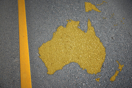 yellow map of oceania on asphalt road near yellow line.