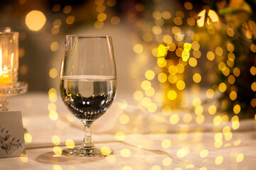 A glass of champagne on table with blur light in restaurant.