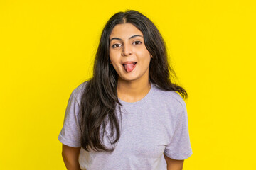 Funny comical playful Indian young woman making silly facial expressions grimacing fooling around,...
