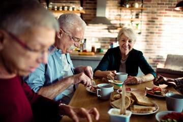 Senior people having breakfast together at home