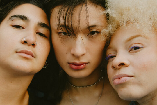 Closeup portrait of three multiracial friends staring into camera