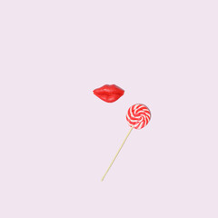 Lollipop with lips on a pink background. Christmas fashio cosmetic concept.