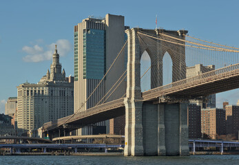 brooklyn bridge view over hudson river with nyc skyline background (urban cityscape of manhattan)...