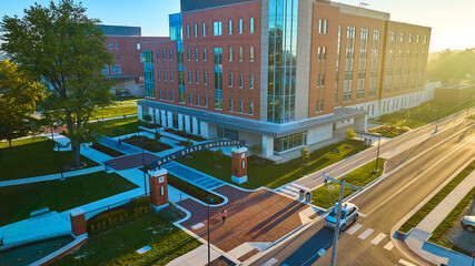 Fototapeta premium Ball State University arch sign over sidewalk with sunny sunrise, Muncie Indiana
