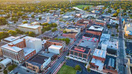 Muncie, IN late afternoon aerial with downtown city buildings, Midwest town near sunset