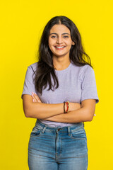 Cheerful lovely happy young Indian woman smiling friendly glad expression looking at camera dreaming resting relaxation feel satisfied good news. Arabian girl isolated on yellow background. Vertical