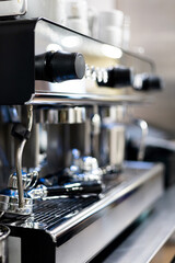 A vertical photo of a coffee machine with two pistons inside a restaurant. Industrial coffee maker concept. Coffee at a bar, morning breakfasts at a coffee shop.