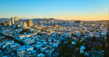 Sunset San Francisco aerial residential area with shadows over buildings and golden light on skyscrapers, CA - obrazy, fototapety, plakaty
