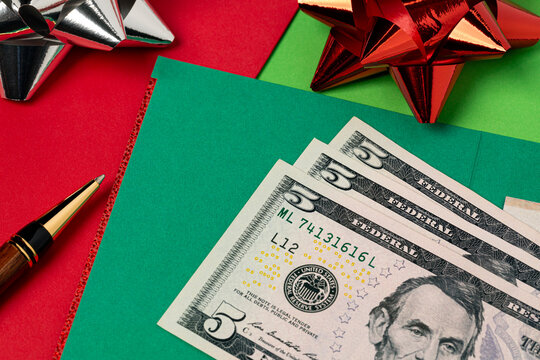 Cash money and holiday greeting cards. Holiday tipping, gratuity, Christmas gift and charitable donation concept.