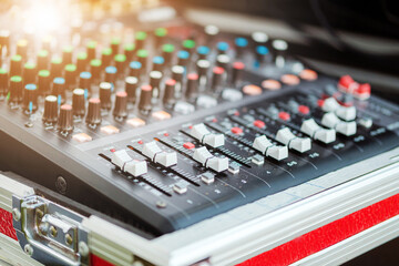 Sound mixer with orange flare at the audio control studio.