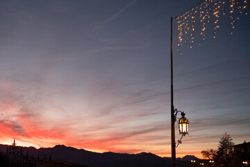 Lamppost lit at dusk with christmas lights © Justo