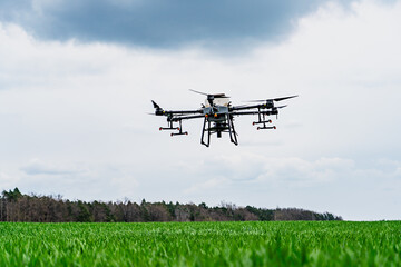 Agriculture drone flying in the sky over a green field