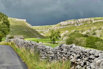 Fototapeta na wymiar The rugged landscape of the Yorkshire Dales under a dark grey sky. 