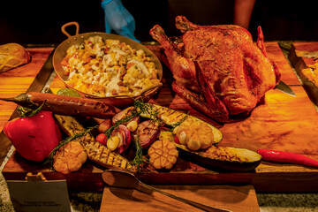 Carving station with meat variety among catering banquet table. Variety of snacks, appetizers, seafood and cooked meals displayed as buffet for wedding, Christmas, business corporate, birthday party