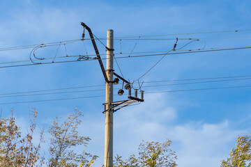 Electrified railway pole on blue sky background. Electric power supply lines on pillars along...