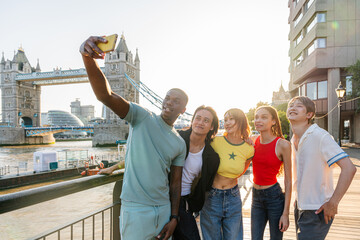 Multiracial group of happy young friends bonding in London city - Multiethnic teens students...
