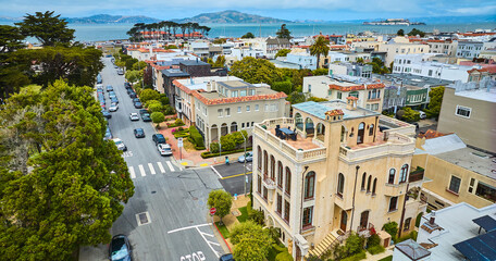 Fancy apartment buildings and hotels on street lined with cars aerial of San Francisco Bay with...