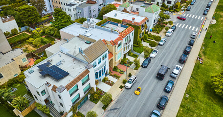 Apartment buildings beside street lined in cars aerial San Francisco, CA